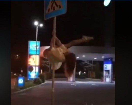 дівчина танцює на дорожньому знаку